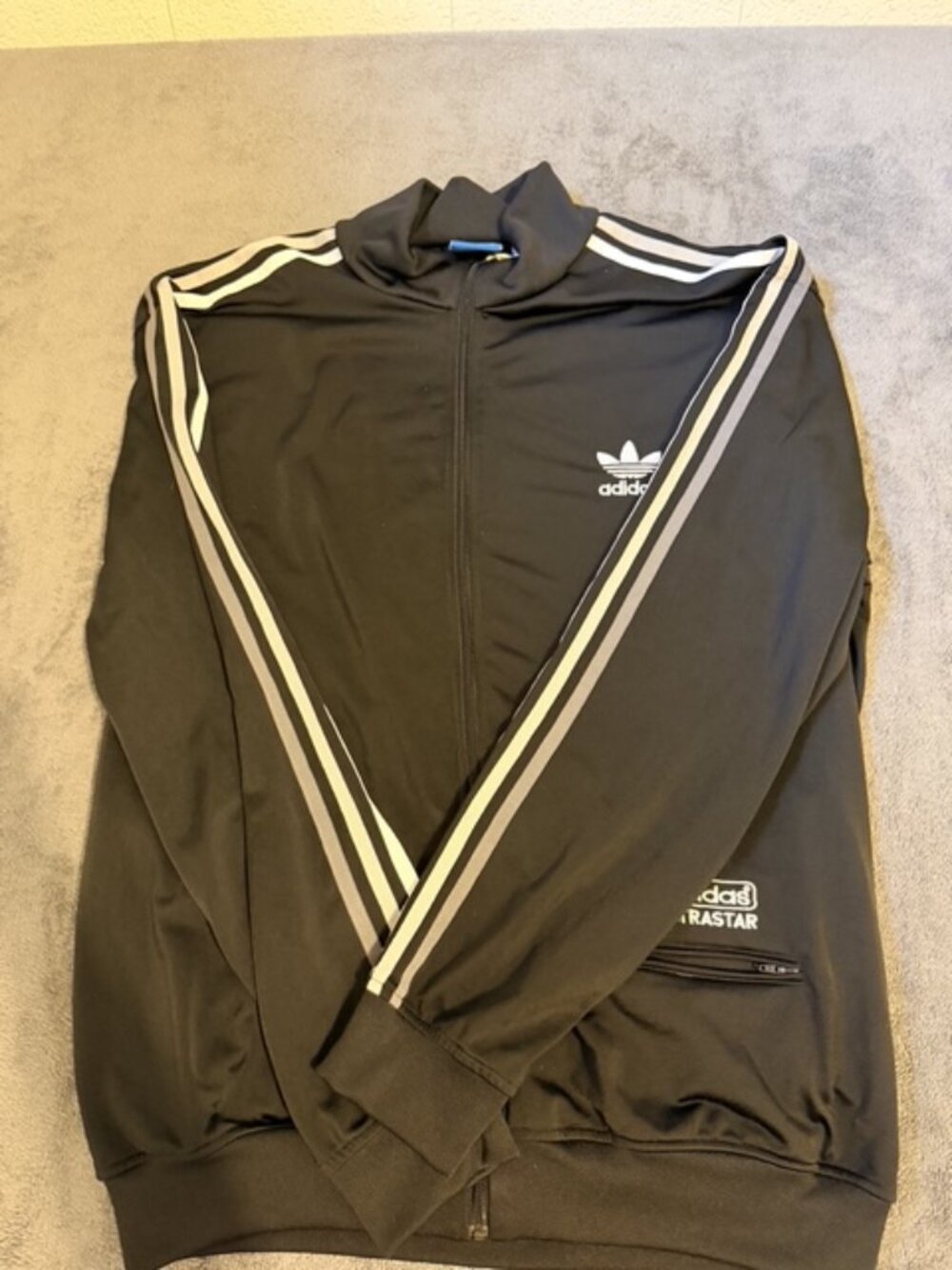 Adidas Originals men's full-zip track jacket in black. Classic trefoil style